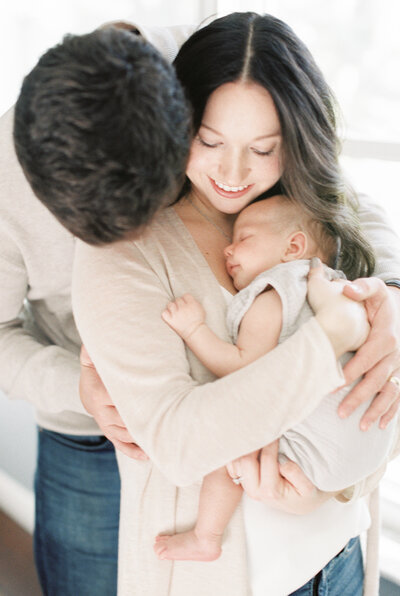 new parents snuggling baby by Orlando baby photographer
