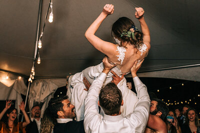 Bride crowd surfing at wedding reception in Colorado