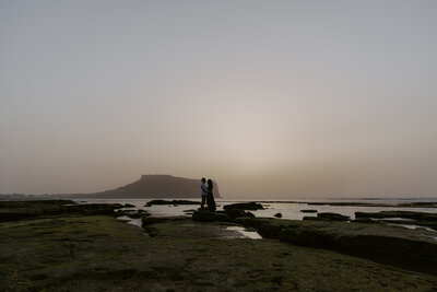 a couple at sunrise peak on jeju island at sunrise