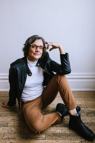 Woman sitting on the floor wearing glasses in a branding photo for Eyenavision and North Point Eyewear of Pittsburgh. 