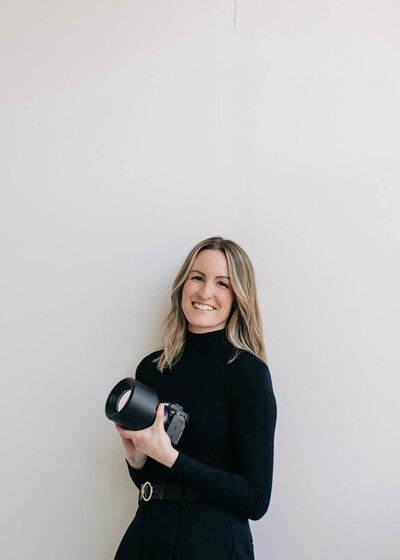 Photographer wearing black holding a camera