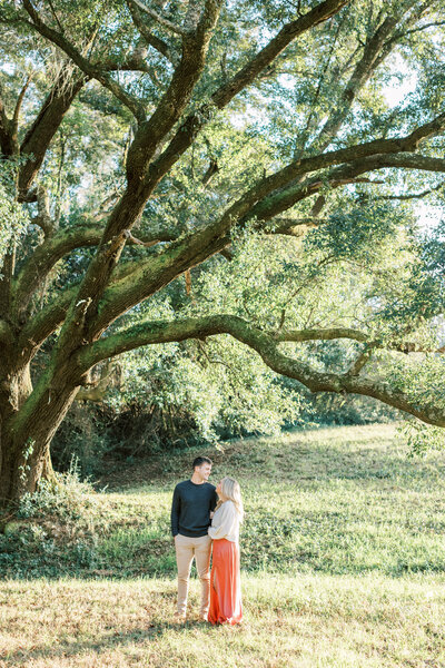 A huge oak tree surrounds the couple.