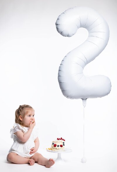Vrolijke cakesmash fotoshoot voor de eerste verjaardag, met kleurrijke taart en feestelijke setting bij Studio 2Shoot in Eijsden.