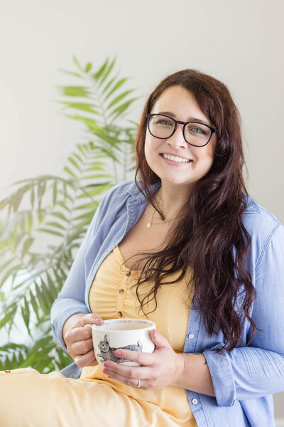 Aubre wearing a white button down shirt standing in front of a sun drenched window