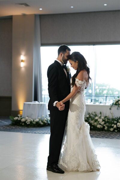 A newlywed couple holding hands and dancing together 