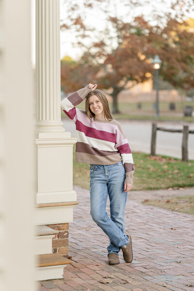 nursing graduate standing in tulips holding Littmann stethoscope in heart shape during golden hour in colonial  Williamsburg 
