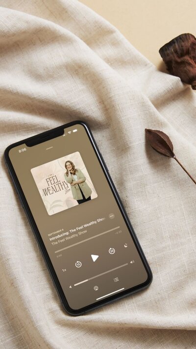 Mockup of The Feel Wealthy Show podcast on an iphone