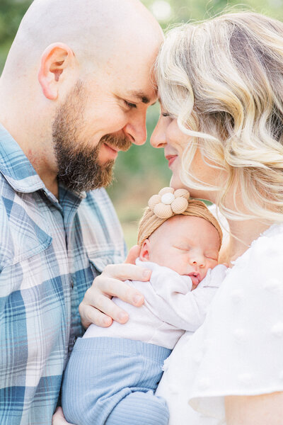 A pregnant mother holds her little boy in her arms in a field of tall grass at Brushy Creek Lake Park, captured by a Cedar Park Maternity Photographer