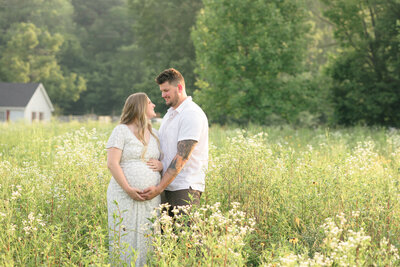Expecting parents standing in a field of wildflowers for their Louisville maternity photos