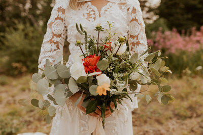 bride holding bouquet and looking out window