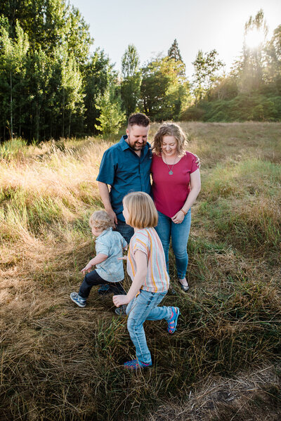 Kids running around parents in field fall family photos golden hour