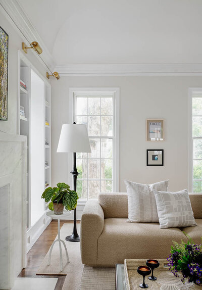 Hingham interior designers designed a Scandinavian living room with a boucle sofa, white metal side table, and simple art for a clean, modern aesthetic.
