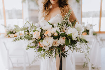 Stunning and elegant bridal bouquet with white and peach florals, created by The Romantiks, romantic wedding florals based in Calgary, AB & Cranbrook, BC. Featured on the Brontë Bride Vendor Guide.