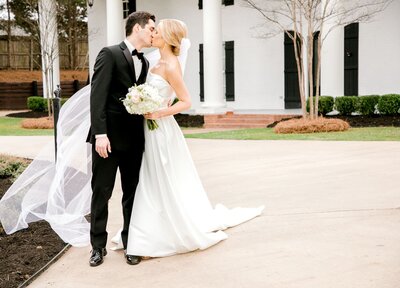 Bride and groom in classic black tux kiss