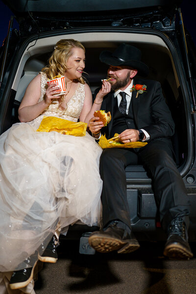Bride and groom laughing and sharing Whataburger food and drinks during their Colorado Springs elopement.