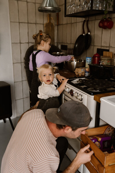gezinsfoto met twee kindjes en papa samen bakken