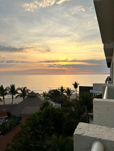 A breathtaking sunset viewed from a resort balcony, perfect for a destination wedding planner's romantic setting.