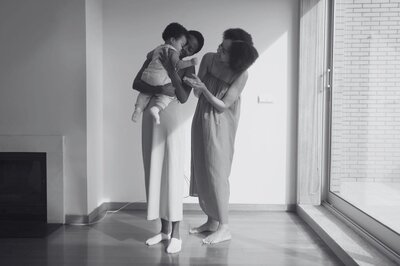 Parents gently holding their baby, showing warmth, care, and a close bond