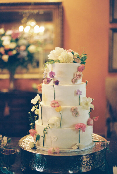 white cake with little flowers stuck on it