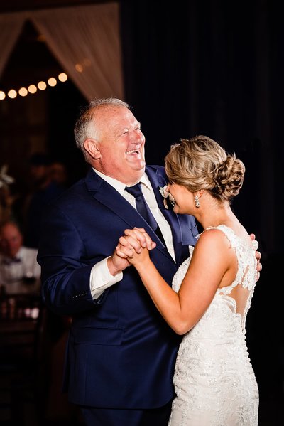 Dad laughing while dancing with his daughter at her Saddlewoods Farm Wedding