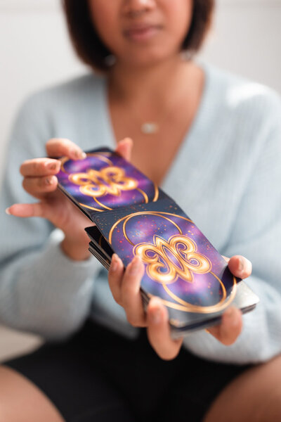 woman holding a deck of tarot cards shuffling them