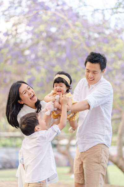 asian malaysian family lawyer playing with his family in brisbane jacarandas from UQ