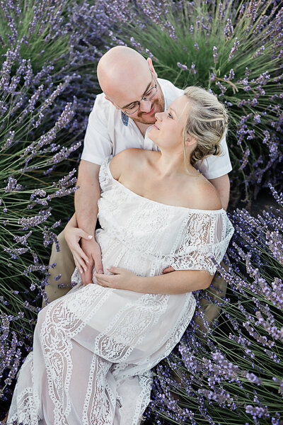 Husband and wife laying in lavender field near Portland Oregon