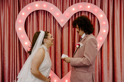 A couple during their wedding ceremony saying their vows and laughing 