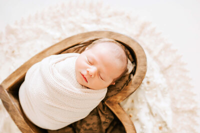 Springfield MO newborn photographer captures mom holding sleeping baby girl in floral crown