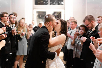 Joyful bubble send-off moment captured by Style & Grace Photography in St. Louis, MO, as the newlyweds make their grand exit surrounded by family, friends, and floating bubbles.