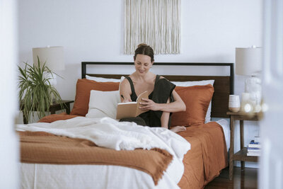 Yoga and Pilates instructor journaling at a table, embodying mindfulness and wellness.