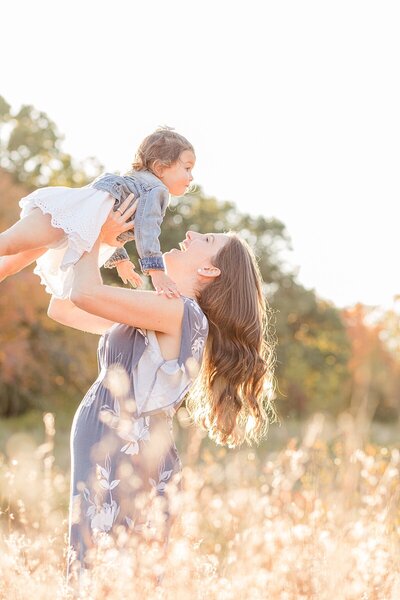 girl sits on dad's shoulders and dad smiles at mom during family photo session with Sara Sniderman Photography in Metro West Boston Massachusetts
