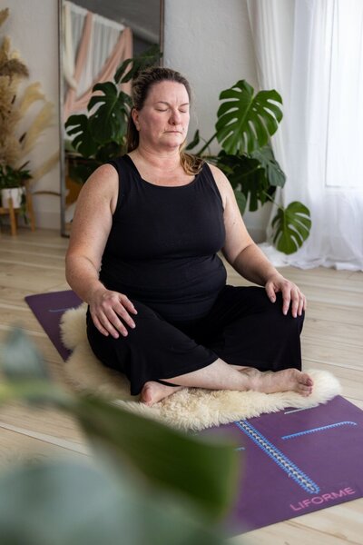 Woman in seated yoga position and meditating.