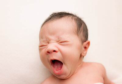 baby yawning on white backdrop