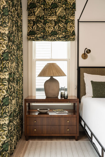 Kids bedroom with cream walls, green trim and door, wooden dresser, yellow mirror and bookshelf
