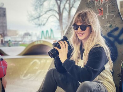 Producer Cassi Angier holds a camera in hands on set.