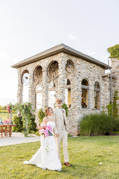 Bride and Groom walking in golden light in front of Castle Vineyard. 