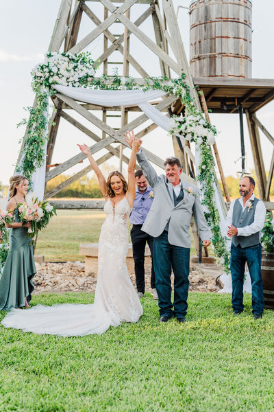 Bride and groom holding  hands  during portraits at the Silo and Oaks wedding venue in Temple Texas photographed by  Belton Wedding Photographer Carmen J Williams Photography.