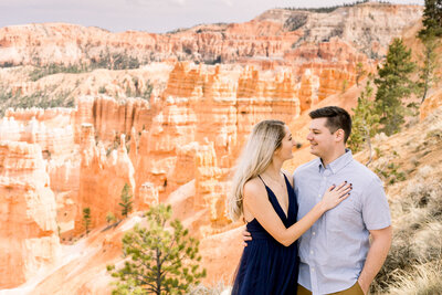 bride and groom sitting on rocks with Lake superior in the background and tall, green, pine trees