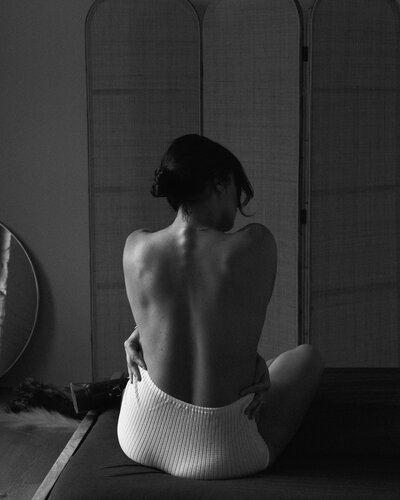 Woman's back topless with white underwear