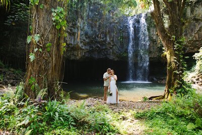 A bride and groom elope on Maui in front of a waterfall