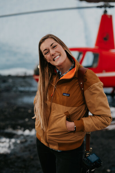 woman standing by helicopter on glacier