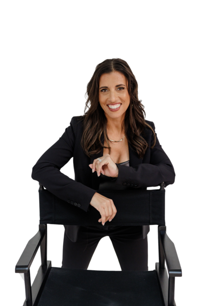 Jocelyn ‘Jo’ Espejo, founder of Branding by Jo, leaning confidently on a director’s chair in a black blazer against a clean white background.