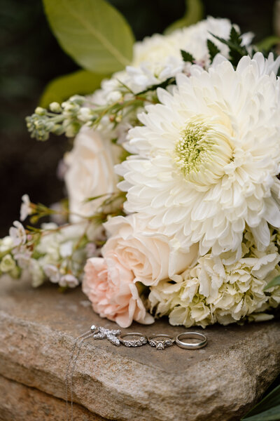 Bride holding up a bouquet of flowers during a beach elopement in Michigan.