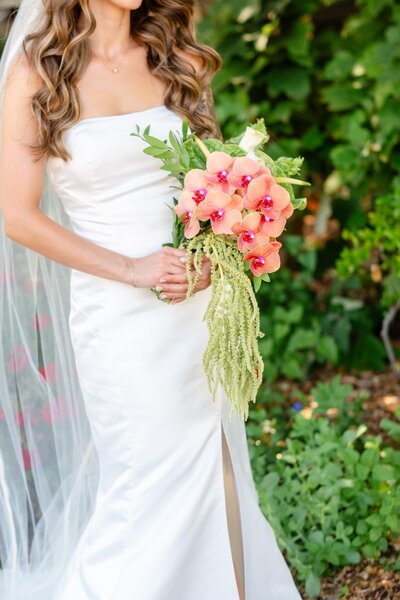 Bride holding flower in a beautiful garden