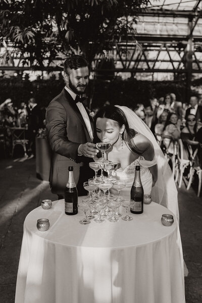 high-end wedding photo with bride and groom at champagne tower