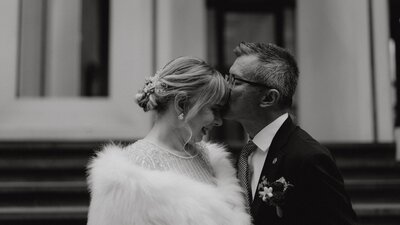 father kissing bride on the forehead