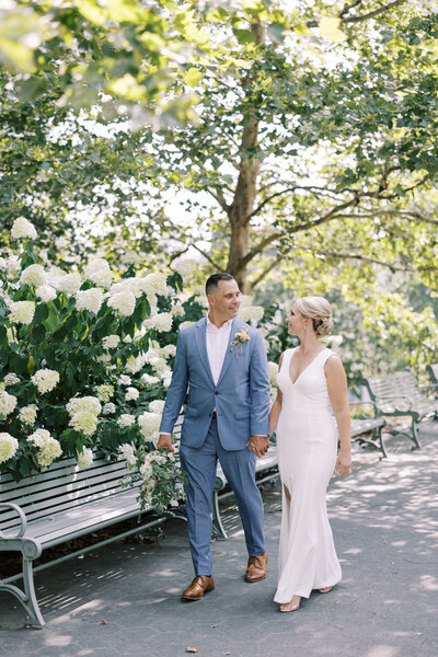Couple walks by elegant hydrangeas after getting married at the PA Courthouse