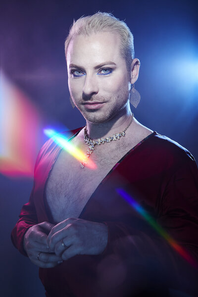 Vibrant and creative portrait of Dain with dramatic lighting and lens flare effects, exuding a bold and modern aesthetic, captured by Ylva Erevall.