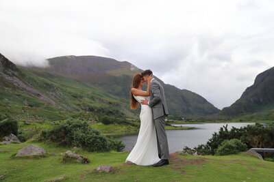 Irish couple kissing by the lakeside mountain view during elopement shoot